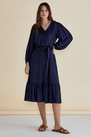 A model wearing the Melissa Dress in colour Darkblue (Blue), from the front, showing the whole outfit