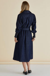 A model wearing the Denmark Denim Dress in colour Darkink (Blue), from the back