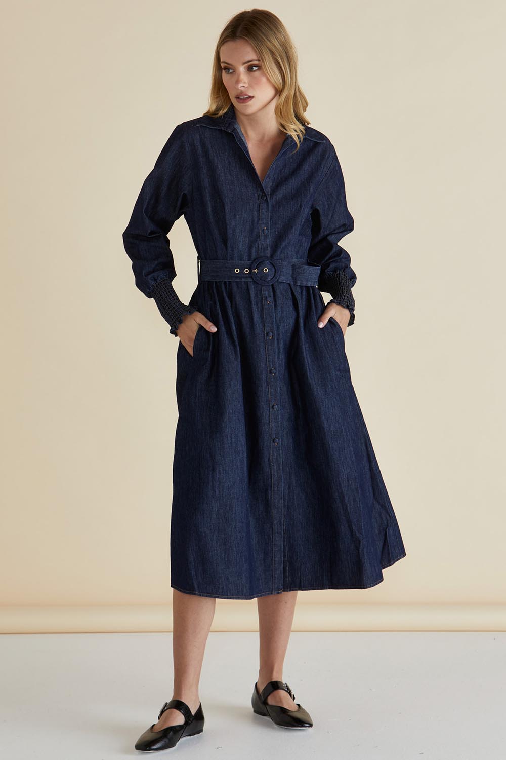 A model wearing the Denmark Denim Dress in colour Darkink (Blue), from the front, showing the whole outfit