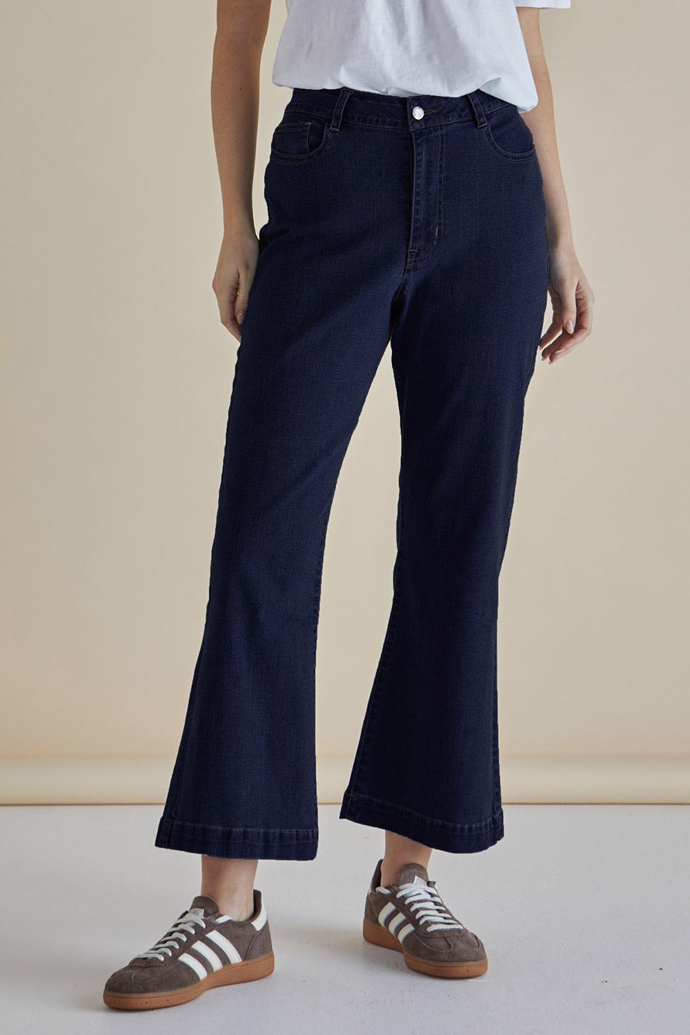 A model wearing the Fleur Bootleg Jean in colour Smokeink (Blue), from the front, cropped image