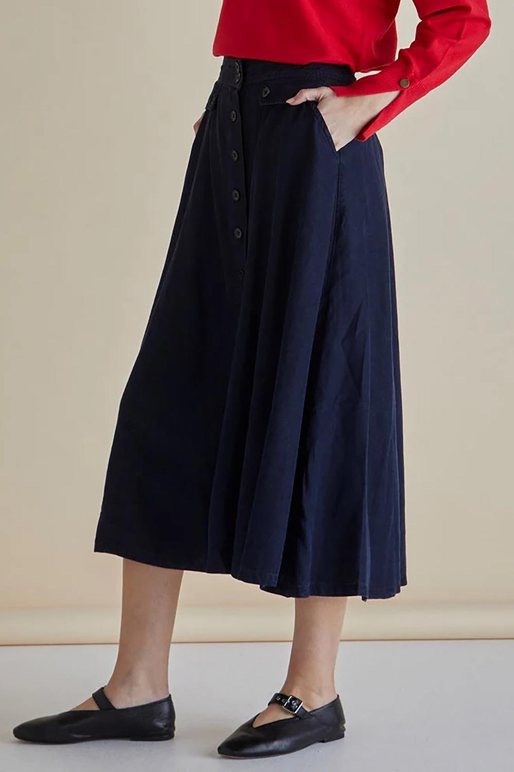 A model wearing the Lola Lyocell Skirt in colour Drkvintage (Blue), from the front, cropped image