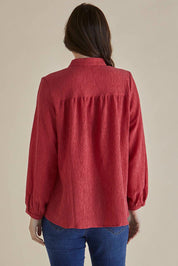 A model wearing the Marie Blouse in colour DustyPink (Pink), from the back