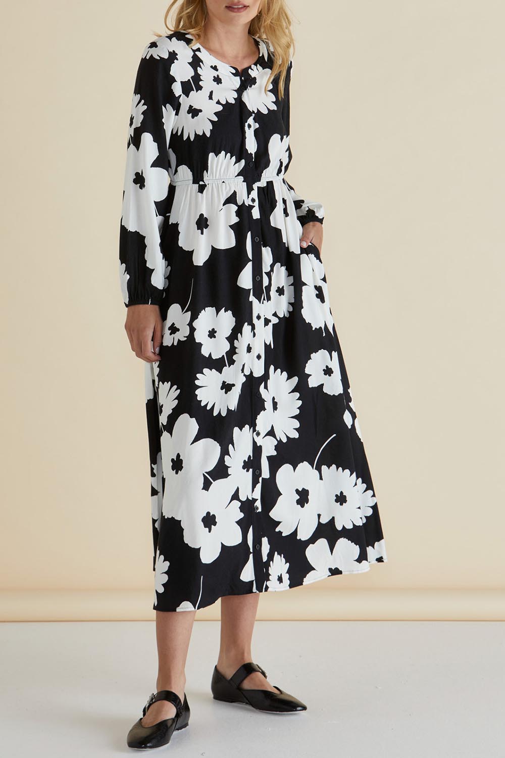 A model wearing the Aries Dress in colour Floral (Black), from the front, cropped image