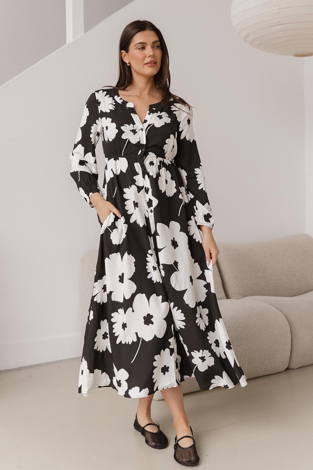 A model wearing the Aries Dress in colour Floral (Black), from the front, showing the whole outfit