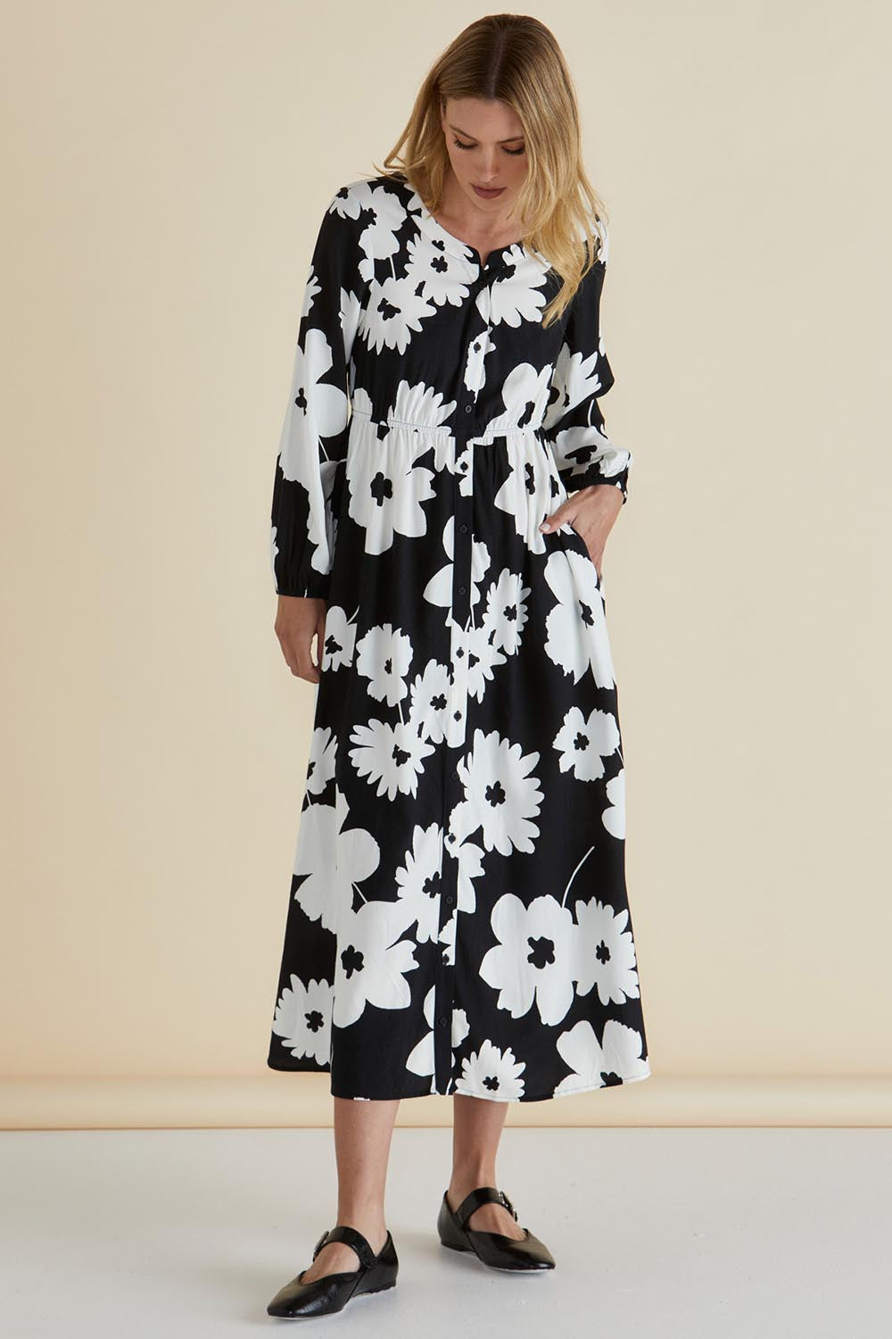 A model wearing the Aries Dress in colour Floral (Black), from the front, showing the whole outfit