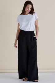 A model wearing the Zander Pant in colour Black (Black), from the front, showing the whole outfit