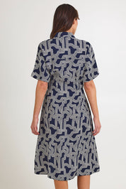 Model Madeline wearing size 10 of the Skye Dress in colour Navygeo (Blue), from the back