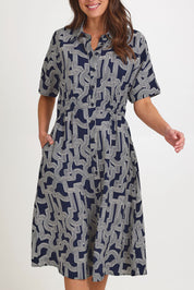 Model Madeline wearing size 10 of the Skye Dress in colour Navygeo (Blue), from the front, cropped image