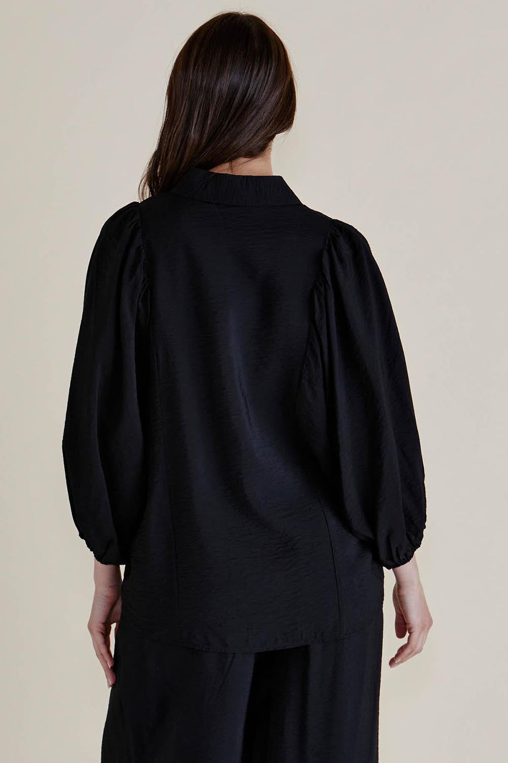 A model wearing the Rosalind Shirt in colour Black (Black), from the back