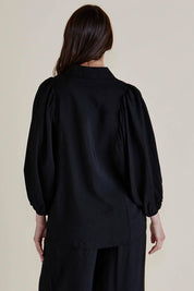 A model wearing the Rosalind Shirt in colour Black (Black), from the back