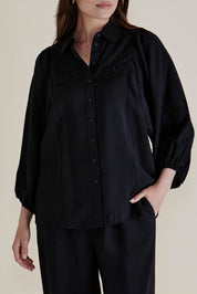 A model wearing the Rosalind Shirt in colour Black (Black), from the front, cropped image