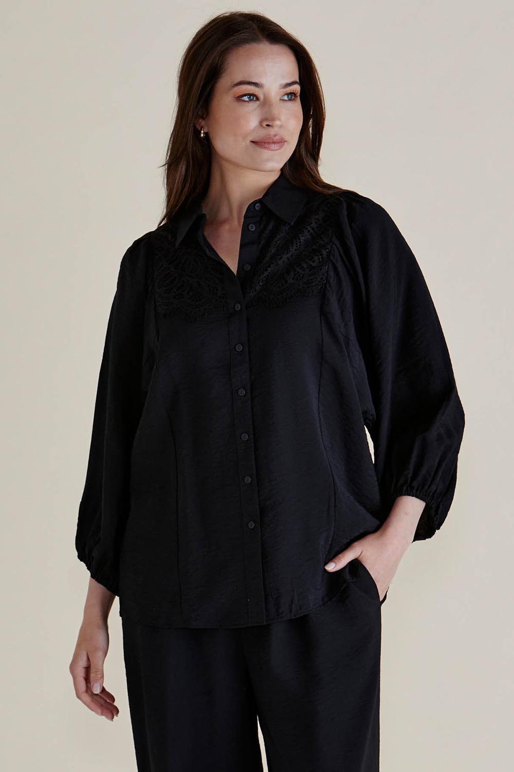 A model wearing the Rosalind Shirt in colour Black (Black), from the front, cropped image