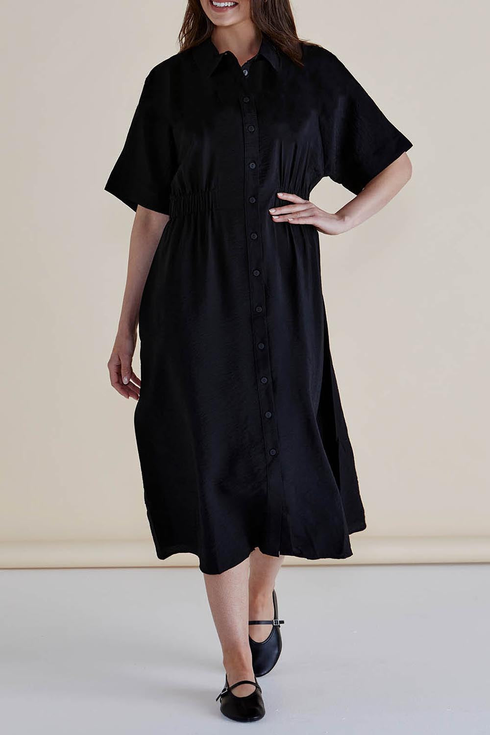A model wearing the Dusk Dress in colour Black (Black), from the front, cropped image