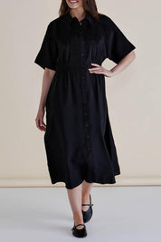 A model wearing the Dusk Dress in colour Black (Black), from the front, cropped image