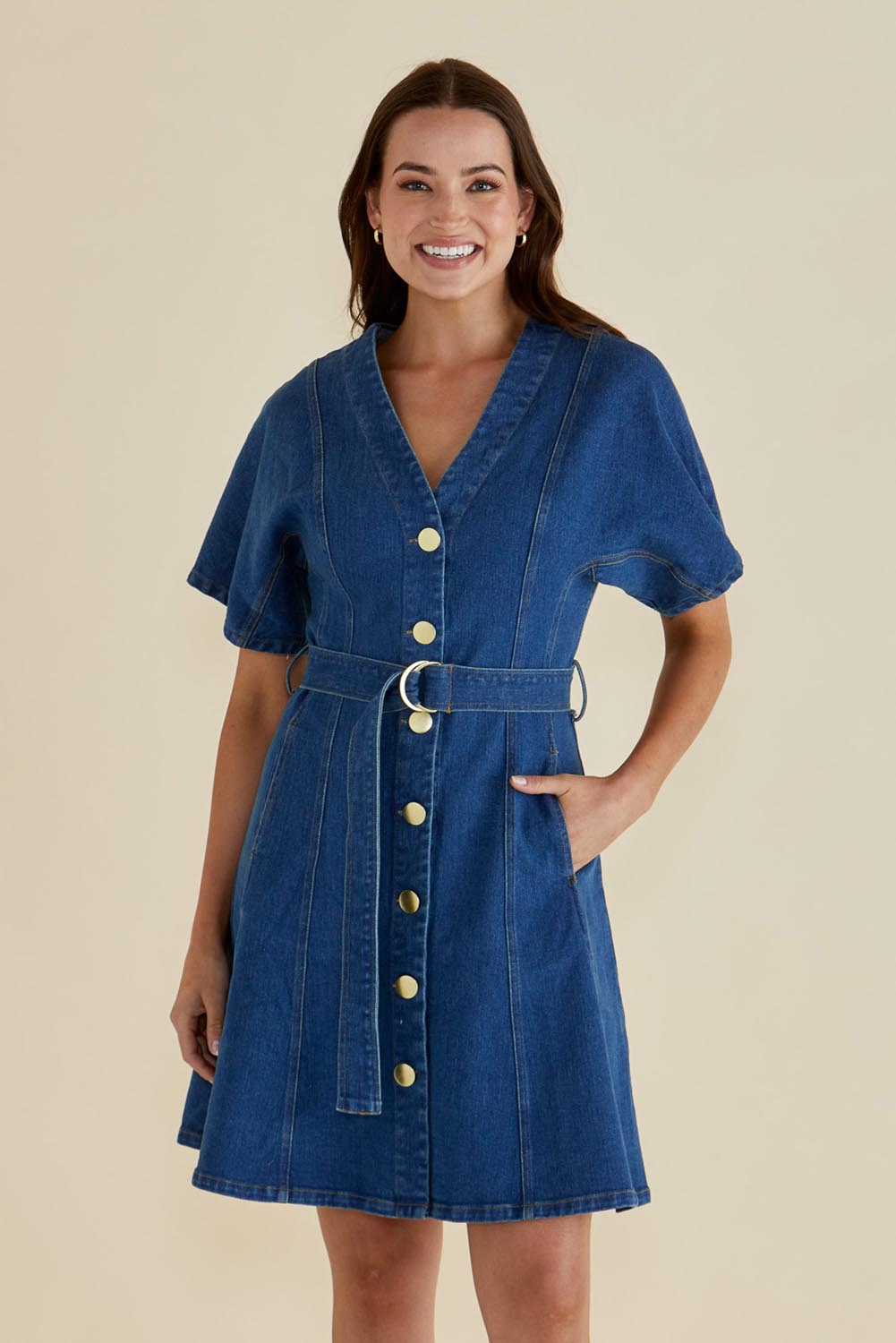 A model wearing the Fiori Denim Dress in colour Midwash (Blue), from the front, cropped image