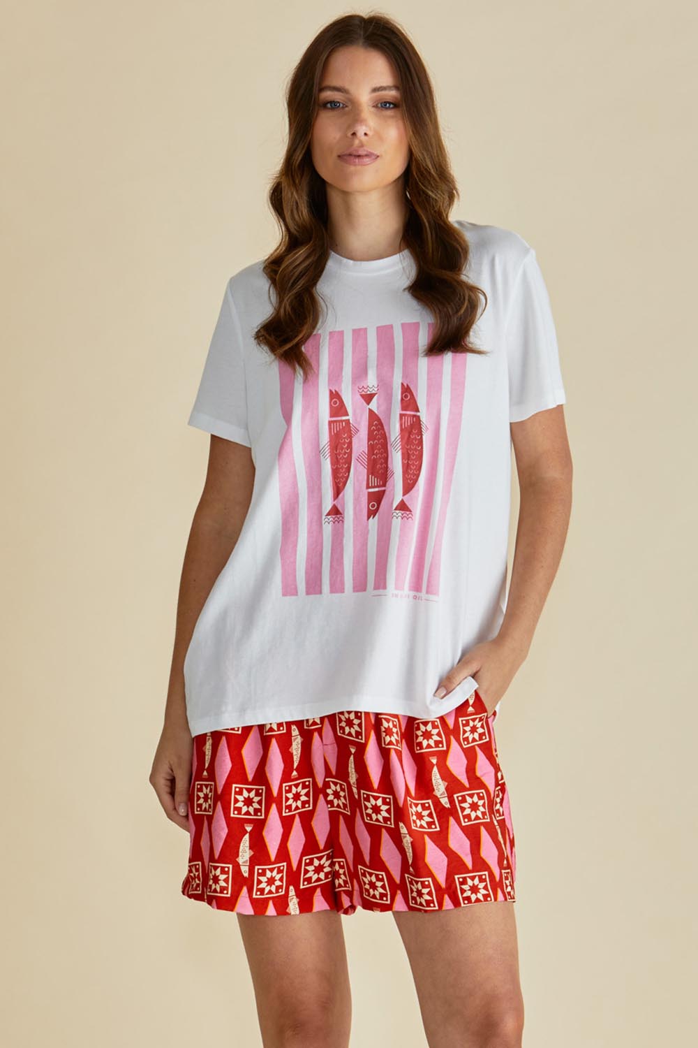 A model wearing the Copacabana Short in colour Sardinia (Red), from the front, cropped image