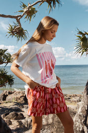 A model wearing the Copacabana Short in colour Sardinia (Red), from the front, showing the whole outfit