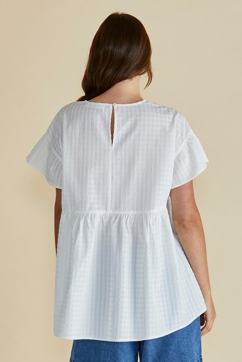 A model wearing the Poppy Cotton Blend Blouse in colour White (White), from the back
