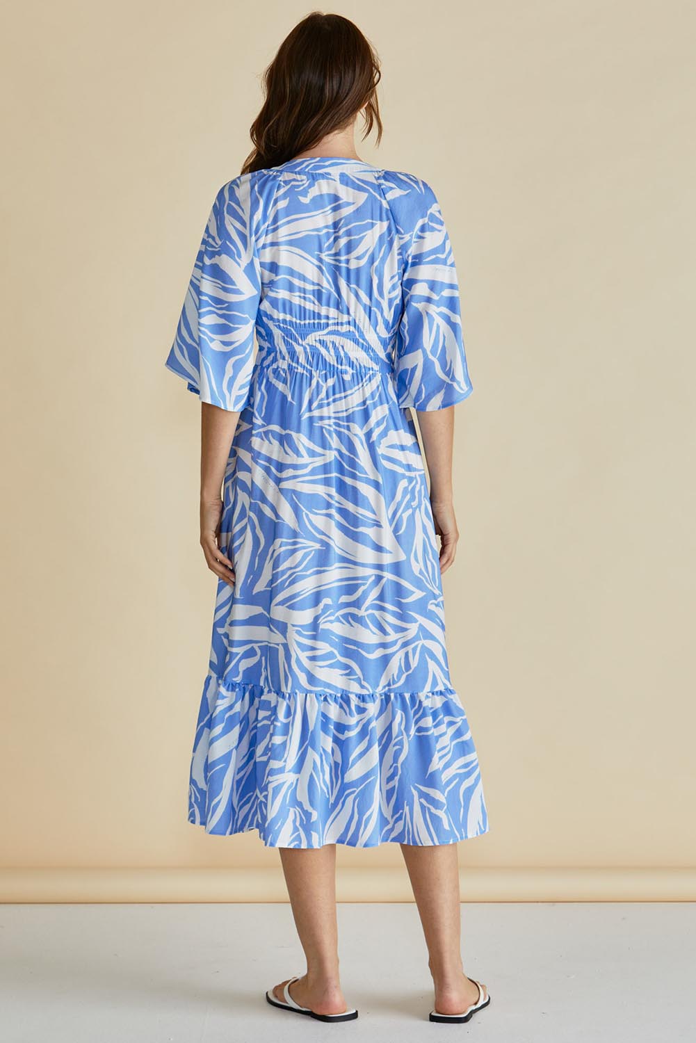 A model wearing the Moxie Dress in colour Blue (Blue), from the back