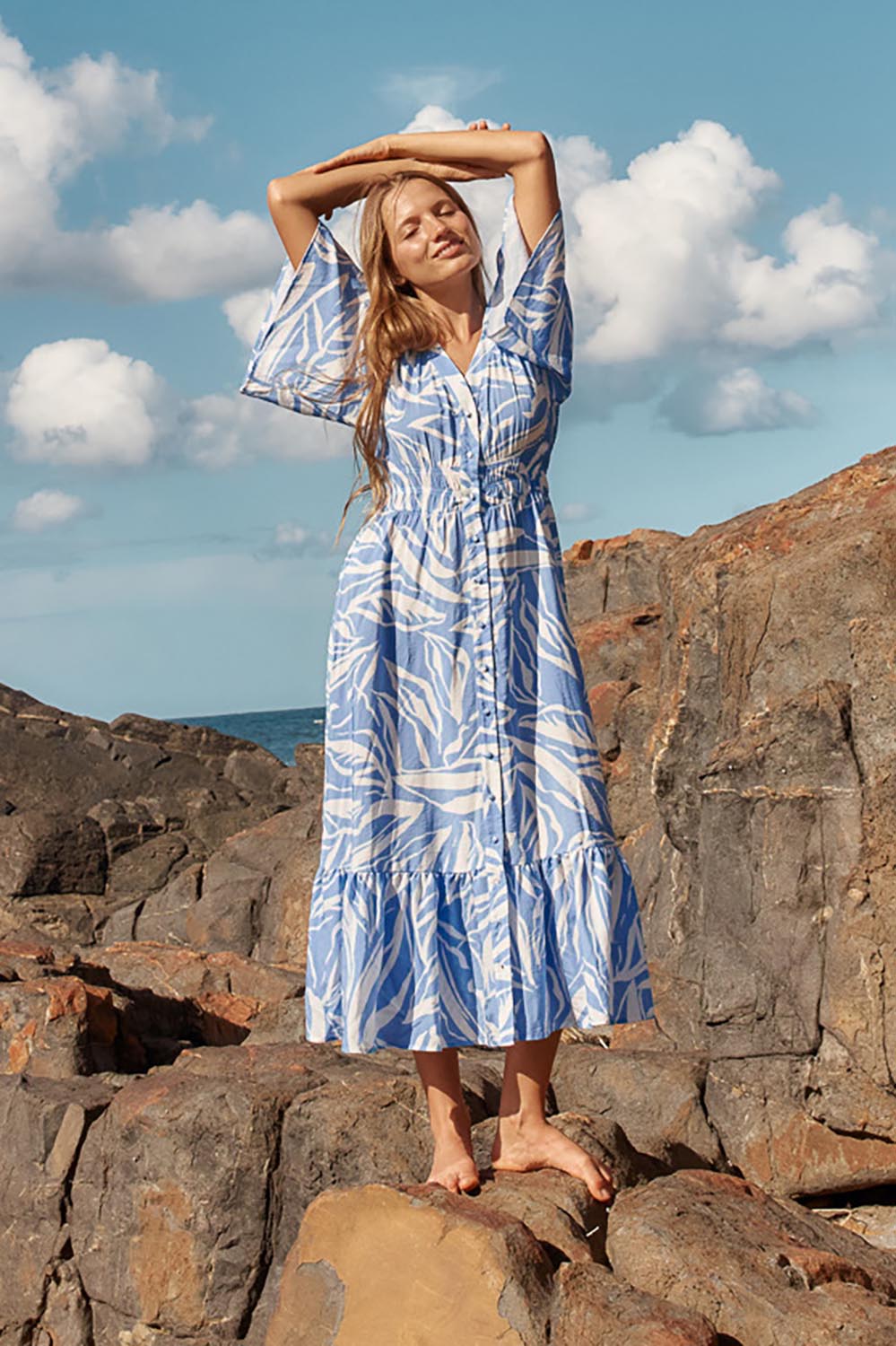 A model wearing the Moxie Dress in colour Blue (Blue), from the front, showing the whole outfit