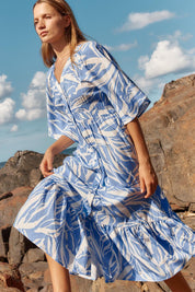 A model wearing the Moxie Dress in colour Blue (Blue), from the front, showing the whole outfit