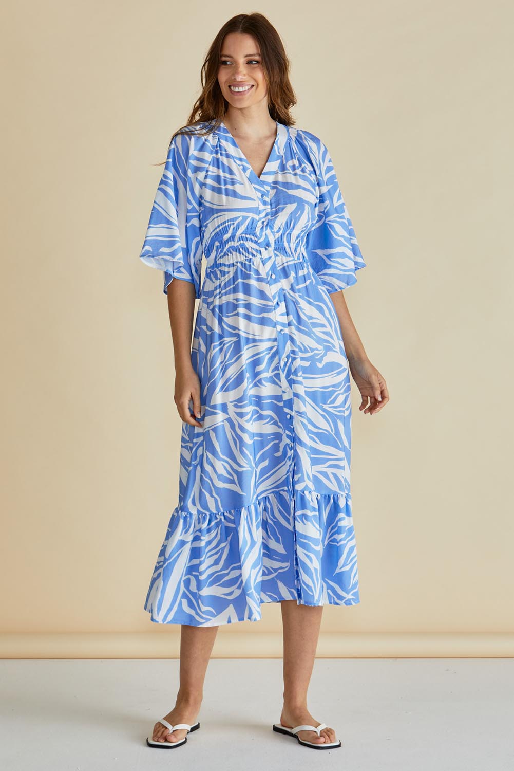 A model wearing the Moxie Dress in colour Blue (Blue), from the front, showing the whole outfit