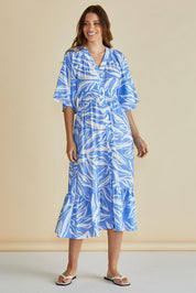 A model wearing the Moxie Dress in colour Blue (Blue), from the front, showing the whole outfit