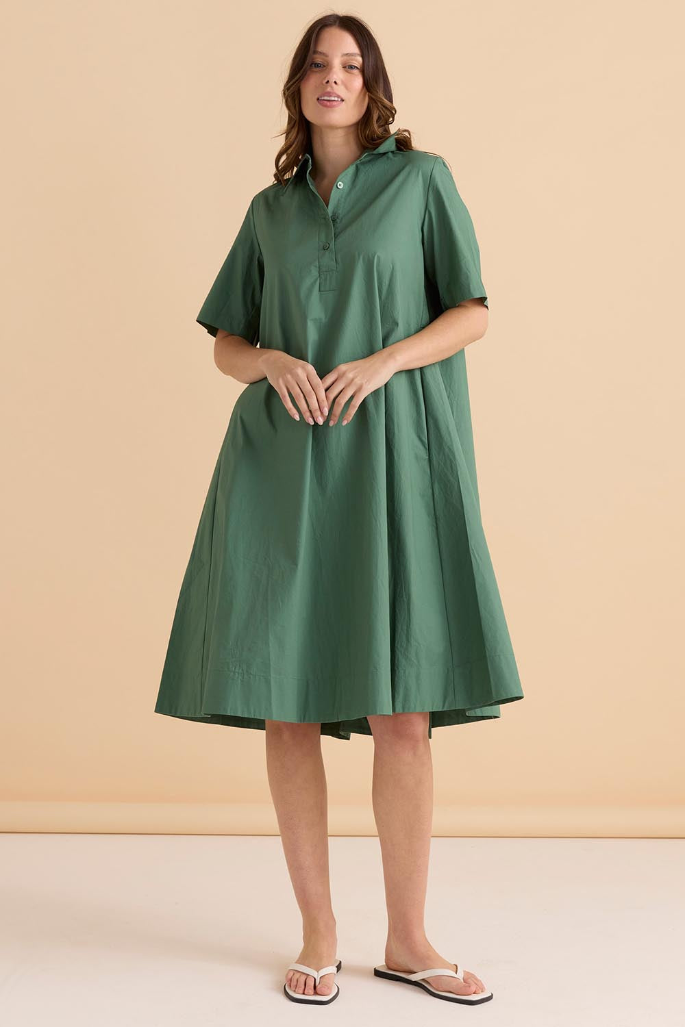 A model wearing the Savannah Cotton Swing Shirt Dress in colour Green (Green), from the front, showing the whole outfit