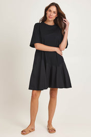 Model Madeline wearing size 10 of the Cassidy Cotton Dress in colour Black (Black), from the front, showing the whole outfit
