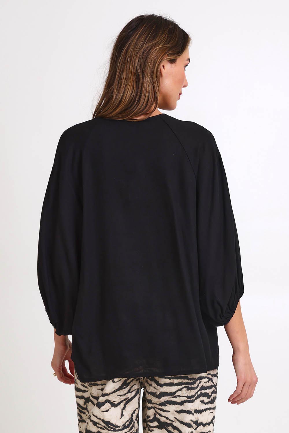 Model Madelinec wearing size 10 of the Bella Blouse – Black in colour Black, from the back