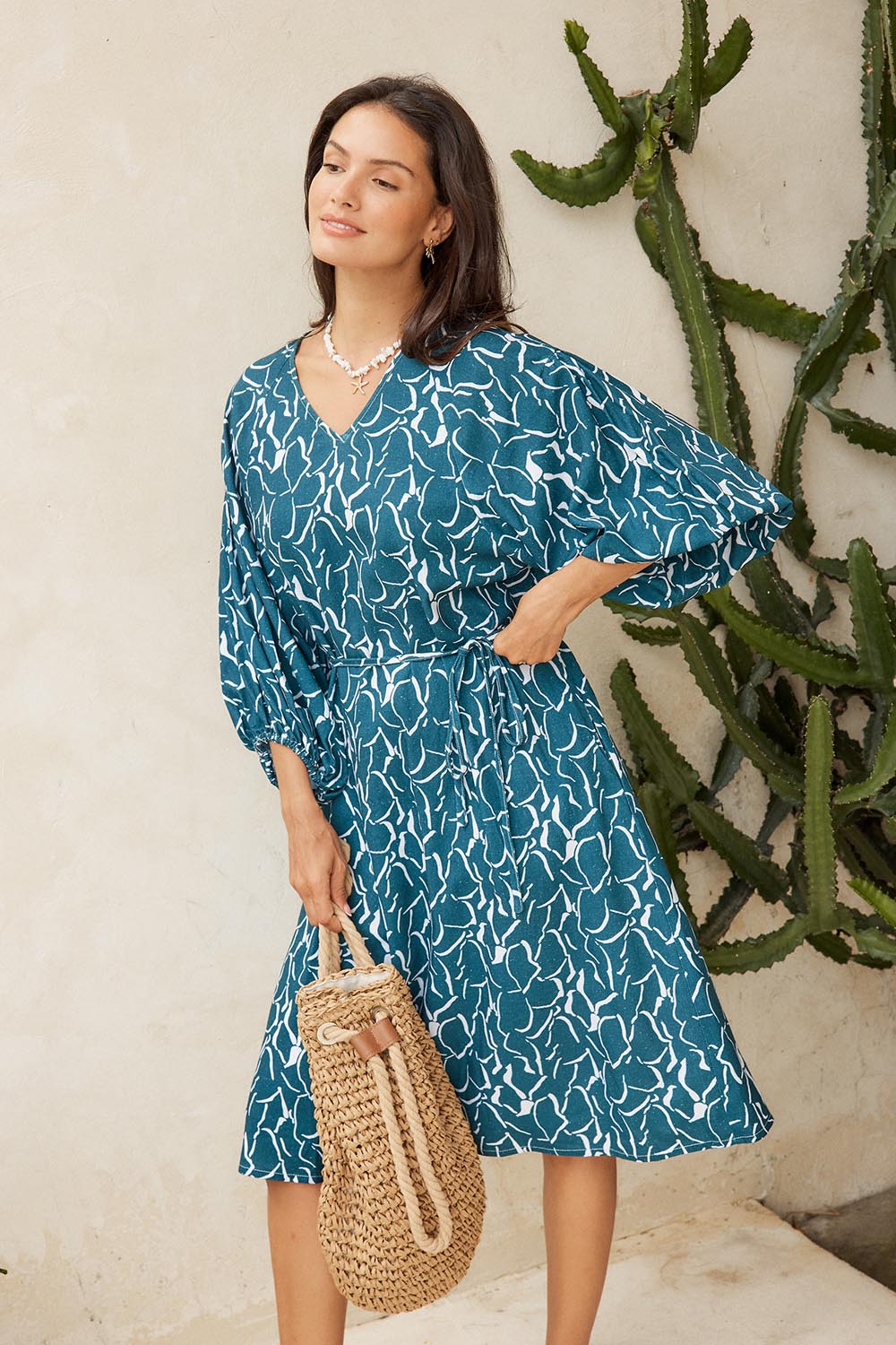 Model Genericm wearing size sample of the Bella Dress – Teal in colour Teal, from an angle
