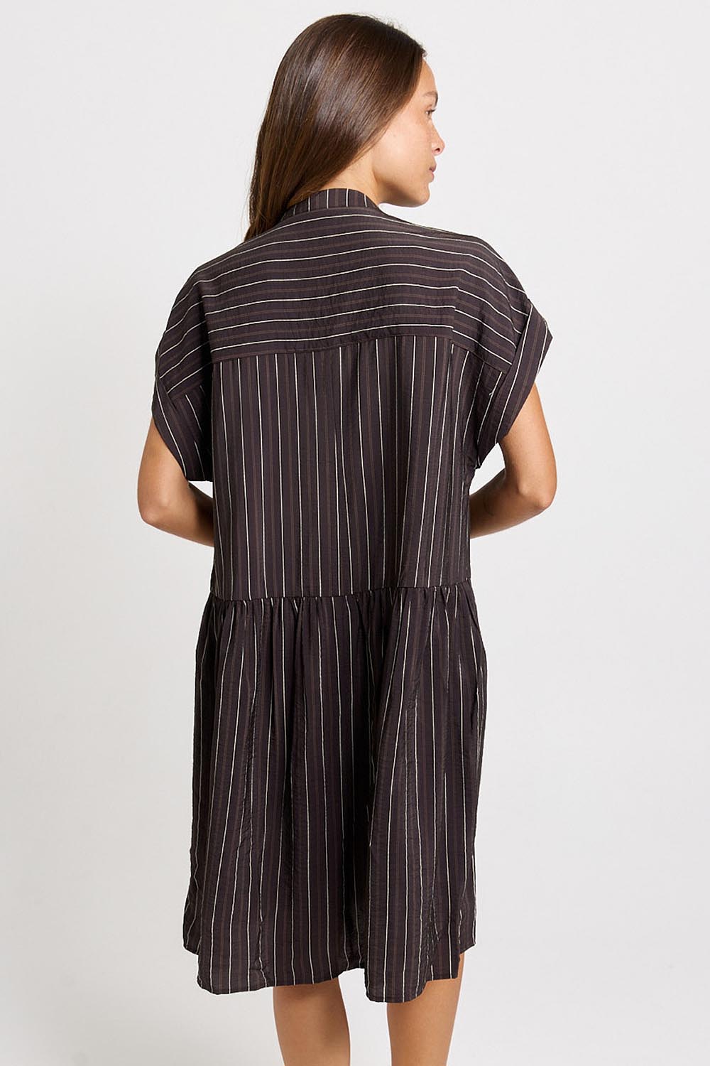 Model Genericm wearing size sample of the Sandy Dress – Brown in colour Brown, from the back