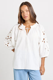 Model Genericm wearing size sample of the Daisy Broderie Blouse – White in colour White, in a cropped view