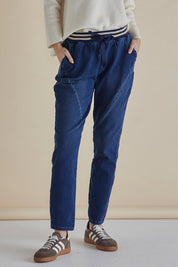 A model wearing the Dakota Denim Pant in colour Bayblue (Blue), from the front, cropped image