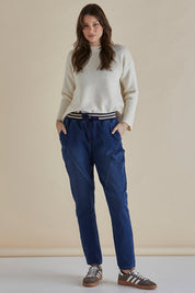 A model wearing the Dakota Denim Pant in colour Bayblue (Blue), from the front, showing the whole outfit