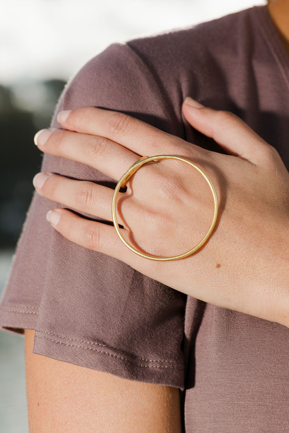 A model wearing size OneSize of the Brass Oversize Circle Ring in colour Goldbrass (Metallics), from the front, showing the whole outfit