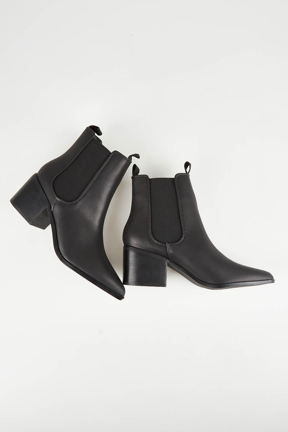 A model wearing size 37 of the Vegan Leather Pull On Heeled Boot in colour Black (Black), from the front, showing the whole outfit