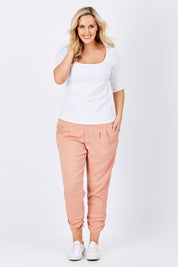 Model Jess wearing size 14 of The Best Seller Pant in colour Clay (Pink), from the front, showing the whole outfit