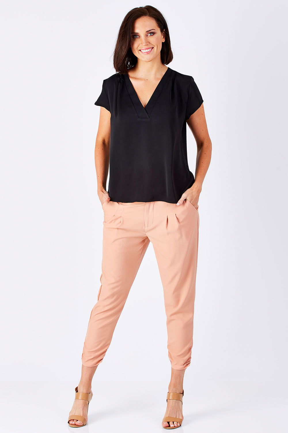 Model Perrie wearing size 10 of The Best Seller Pant in colour Clay (Pink), from the front, showing the whole outfit