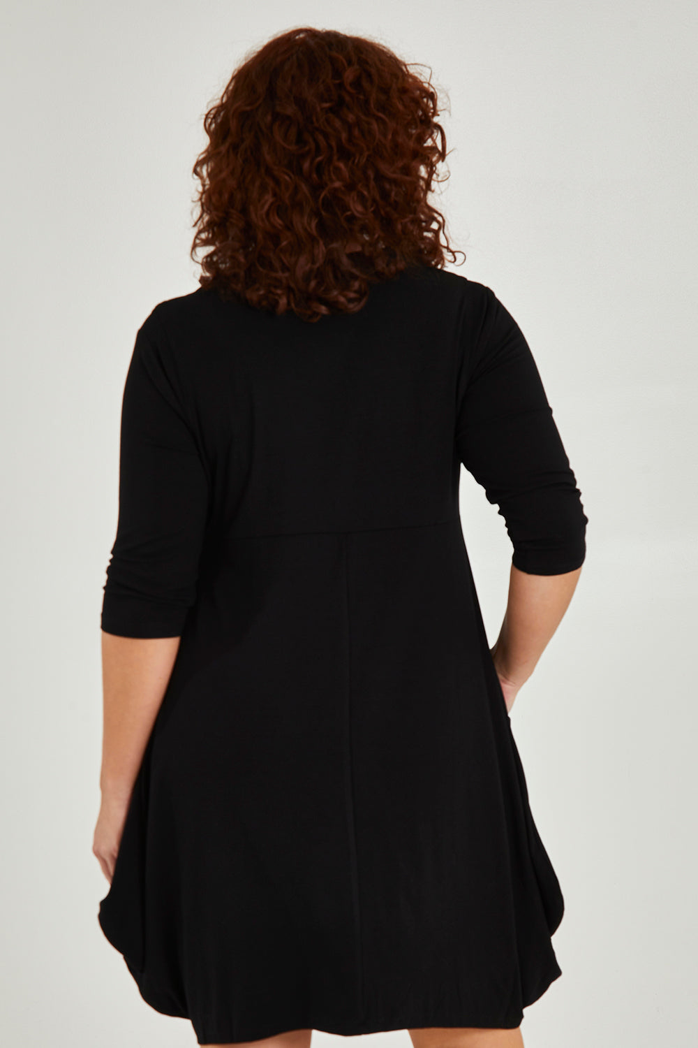 Model Maddy wearing size 16 of The Pocket Tunic Dress in colour Black (Black), from the back