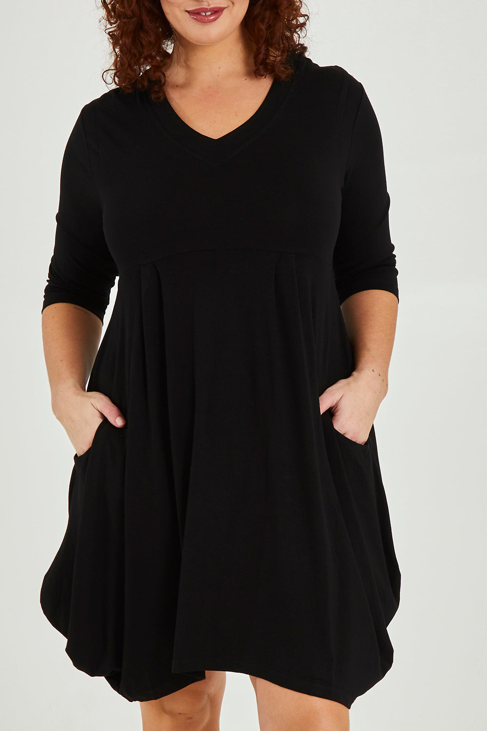 Model Maddy wearing size 16 of The Pocket Tunic Dress in colour Black (Black), from the front, cropped image