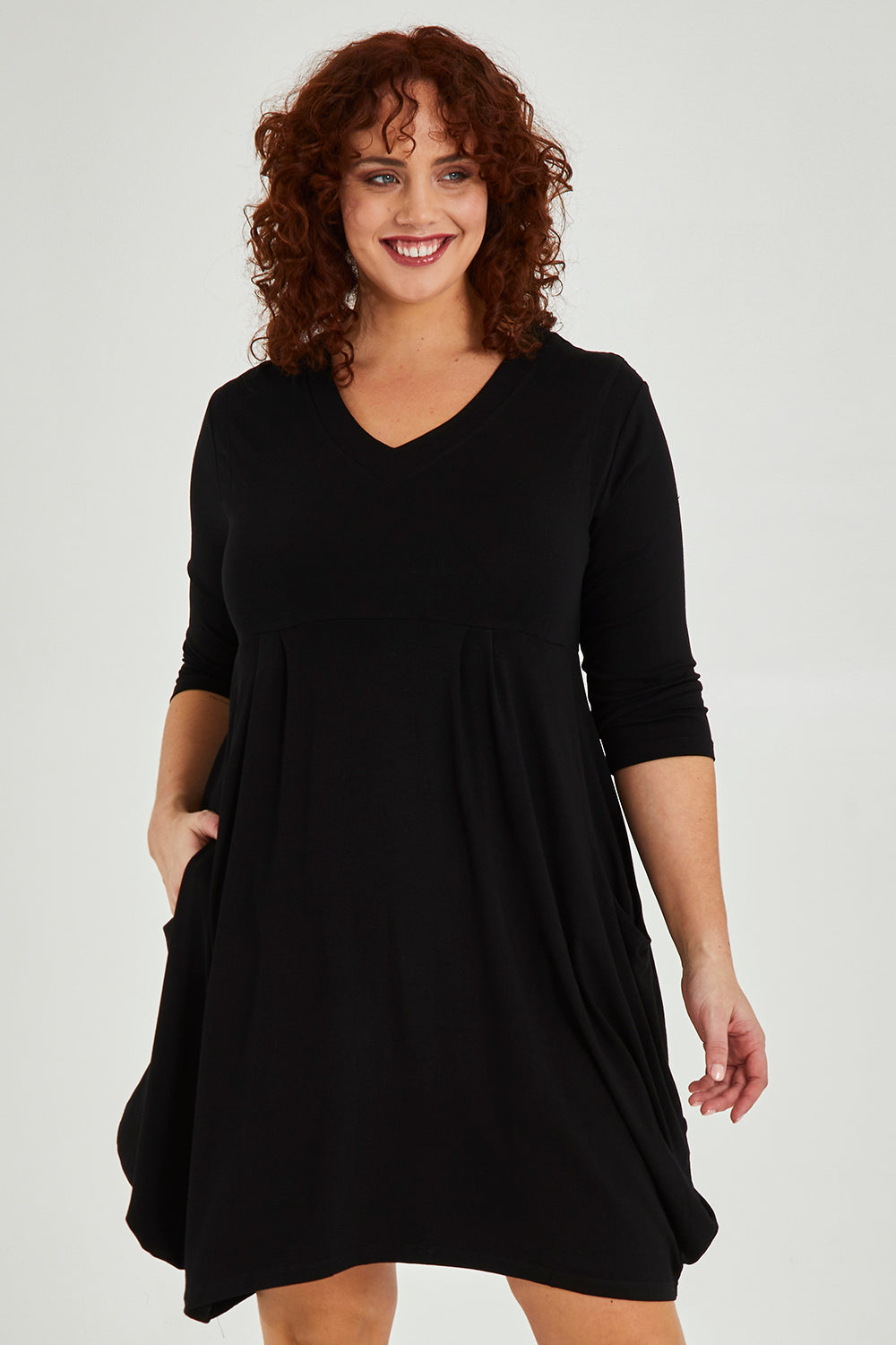 Model Maddy wearing size 16 of The Pocket Tunic Dress in colour Black (Black), from the front, cropped image