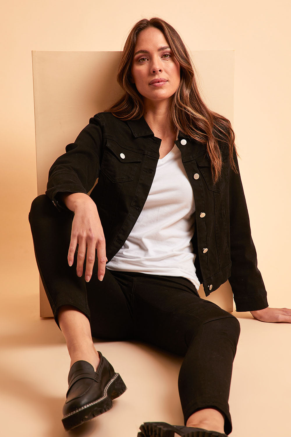 Model Madeline wearing size 10 of The Denim Jacket in colour Black (Black), from the front, showing the whole outfit