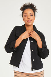 Model Noli wearing size 14 of The Denim Jacket in colour Black (Black), from the front, cropped image