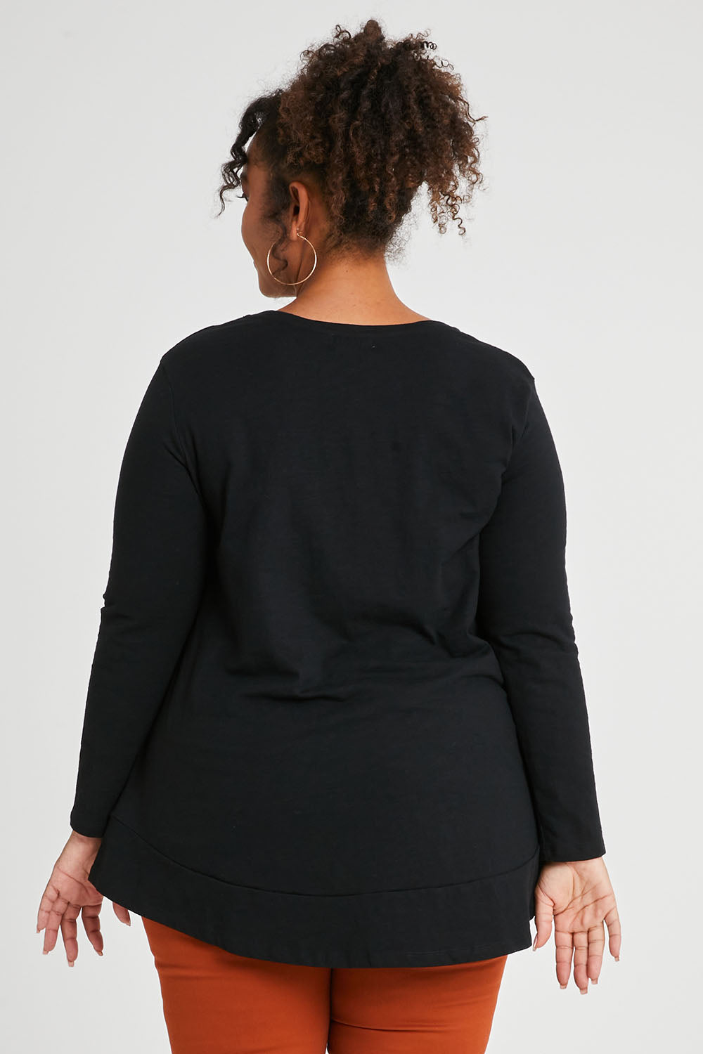 Model Alexis wearing size 16 of The Long Sleeve Swing Tee in colour Black (Black), from the back