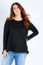Model Laura wearing size 12 of The Long Sleeve Swing Tee in colour Black (Black), from the front, cropped image