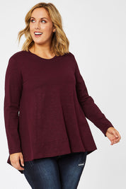 Model Jess wearing size 14 of The Long Sleeve Swing Tee in colour Shiraz (Red), from the front, cropped image