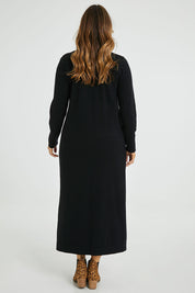 Model Laura wearing size L of The Comfort True Knit Dress in colour Black (Black), from the back