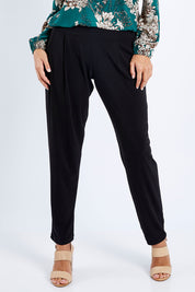 Model Lala wearing size 10 of The Recycled Flat Front Pull On Pant in colour Black (Black), from the front, cropped image
