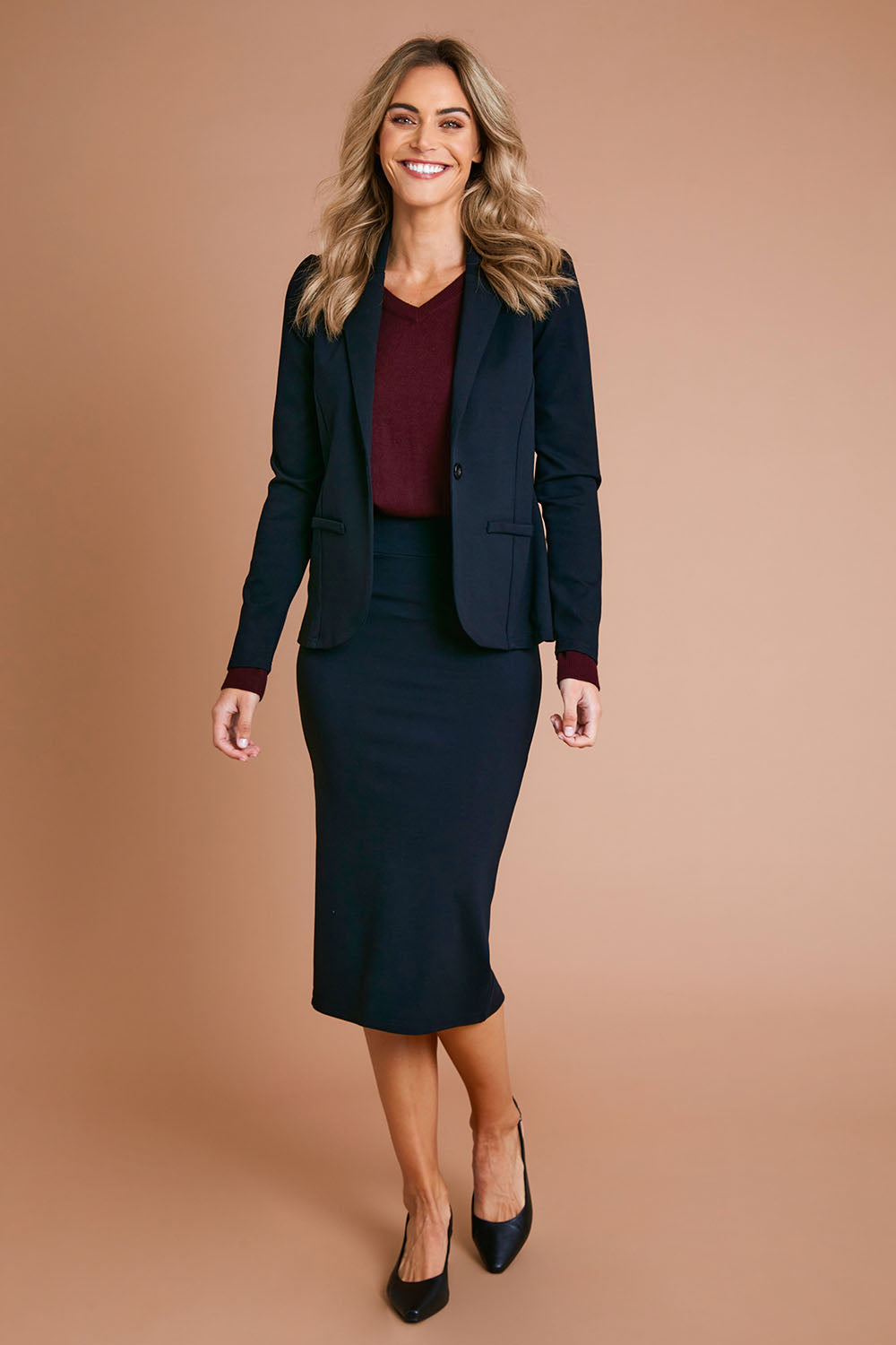 Model Alice wearing size 10 of The Ponte Pull On Midi Skirt in colour Black (Black), from the front, showing the whole outfit